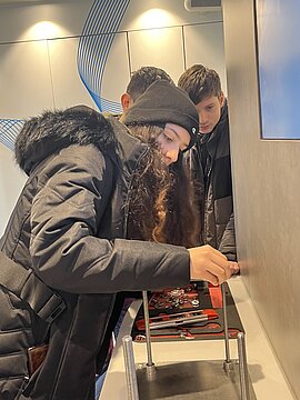 An den Gewindestangen im InfoTruck beweisen die Achtklässler Fingerfertigkeit